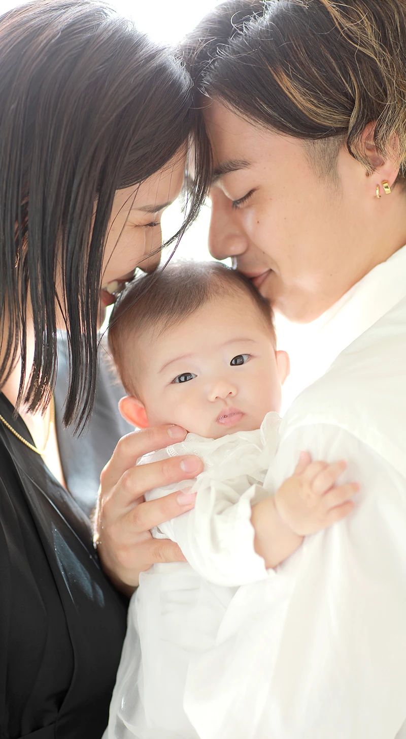 お宮参りの赤ちゃんとお父さんとお母さんの幸せそうな笑顔